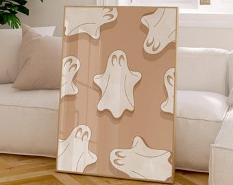 May include: A rectangular framed wall art print featuring a repeating pattern of off-white ghost illustrations with simple oval eyes on a solid light tan background. The artwork is encased in a thin, light-coloured wooden frame.