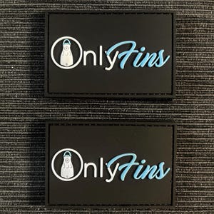 May include: Two black patches with white stitching. Each patch has a white outline of a scuba fin and the text "Only Fins" in white and blue lettering.