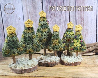 Puede incluir: Un conjunto de seis árboles de Navidad tejidos a crochet en varios tamaños, con hilo verde y amarillo, de pie sobre bases de madera con musgo. Los árboles están decorados con pequeñas cuentas amarillas. La imagen incluye el texto "PDF CROCHET PATTERN".
