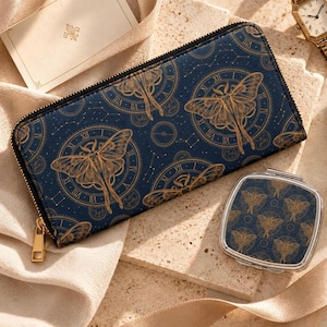 May include: A rectangular navy blue wallet and a square compact mirror, both featuring a gold-toned moth and clock face pattern. The wallet has a gold zip closure, and the mirror has a silver-toned metal frame and hinge.