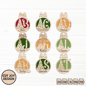 May include: Nine wooden Christmas baubles, each with a name and initial. The baubles feature a Christmas tree design and a bow. Names include Ben, Cassandra, David, Jack, Kate, Liam, Ruby, Sarah, and Thomas. The image also includes the text "CUT JOY DESIGN".