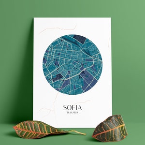May include: A white poster featuring a blue and purple map of Sofia, Bulgaria, in a circular design. The text "SOFIA" and "BULGARIA" is positioned below the map.