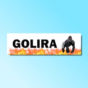 May include: A white banner with the word "GOLIRA" in black text and a black gorilla standing on a bed of orange flames.