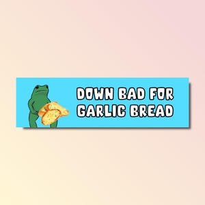Puede incluir: Una rana verde sosteniendo un trozo de pan de ajo con el texto "Down bad for garlic bread" sobre un fondo azul claro.