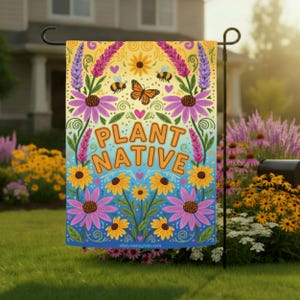 May include: A colorful garden flag with the words "PLANT NATIVE" in orange letters. The flag features illustrations of flowers, bees, and a butterfly against a yellow and blue background. The flag is displayed in a garden.