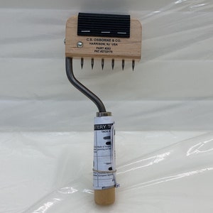 May include: A wooden handled tool with a metal hook and a row of metal tacks. The tool is labeled "C.S. OSBORNE & CO. HARRISON, NJ USA PART #253 PAT #2732175".