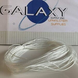 May include: A close-up of a white string wound into a coil. The string is for upholstery and is sold by Galaxy Supply Inc.