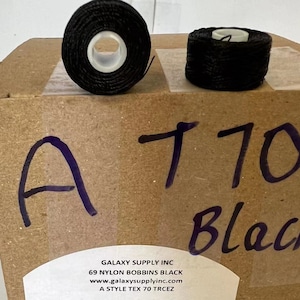 May include: A box of 69 black nylon bobbins labeled "A 170 Black". The box has the text "GALAXY SUPPLY INC 69 NYLON BOBBINS BLACK www.galaxysupplyinc.com A STYLE TEX 70 TRCEZ" printed on it.