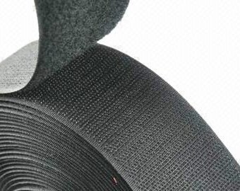 May include: A roll of black hook and loop fastener tape. The tape is made of a soft, flexible material and has a textured surface.