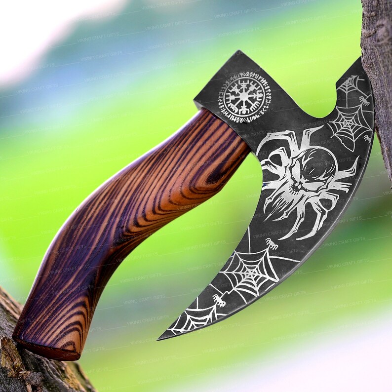 May include: A black axe with a wooden handle. The axe head has a spider web design with a skull in the center. The handle is made of dark wood with a grain pattern. The axe head also has a circular design with runes around the edge.