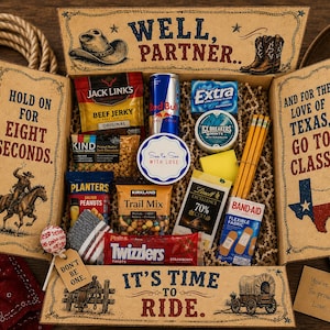 May include: A cardboard gift box with western-themed text and illustrations containing assorted snacks, a Red Bull can, a pack of Extra gum, Ice Breakers mints, a Lindt chocolate bar, Band-Aid strips, pencils, and a lollipop with a tag reading Don't Be One.