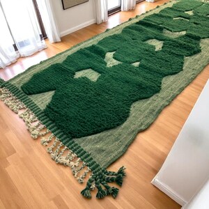 Extra-long Moroccan runner rug in deep green with bold organic patterns and beige wool base. This handcrafted Beni Ourain wool carpet is perfect for hallways, corridors, and modern interiors needing a unique, earthy touch. Made by Berber artisans using natural wool, it combines luxury softness and geometric structure. Ideal for minimalist, boho, or Japandi-style homes.