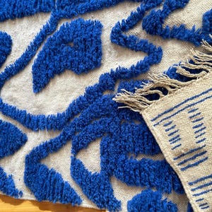 A vintage Moroccan wool rug with a bold blue abstract design handwoven on a neutral beige background, featuring plush texture and traditional fringed edges Vintage Rug, Moroccan Rug Wool Rug Abstract Rug Handwoven Rug Blue Rug Bold Design Modern Rug