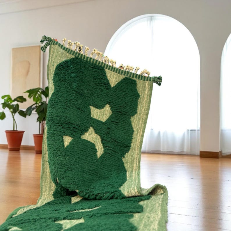 Extra-long Moroccan runner rug in deep green with bold organic patterns and beige wool base. This handcrafted Beni Ourain wool carpet is perfect for hallways, corridors, and modern interiors needing a unique, earthy touch. Made by Berber artisans using natural wool, it combines luxury softness and geometric structure. Ideal for minimalist, boho, or Japandi-style homes.