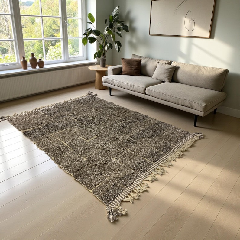 Handwoven Moroccan rug made from 100% natural wool in Travertine and White tones. Its rich texture and neutral color palette make it the perfect statement piece for modern, minimalist, or boho interiors. Crafted by Amazigh artisans in the Atlas Mountains, this rug combines traditional Moroccan weaving with a soft, earthy design. Ideal for living rooms, bedrooms, or cozy reading spaces, it brings warmth and timeless elegance to your home.