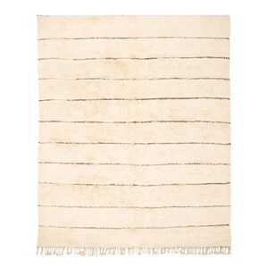Handmade Moroccan rug with minimalist horizontal striped design, crafted from plush wool in a warm beige tone. Soft and cozy, this rug is ideal for living rooms, bedrooms, or modern spaces. Subtle fringes add a touch of traditional elegance.