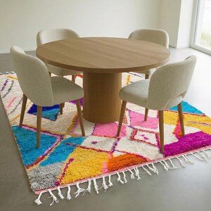 Authentic handmade Moroccan Boujaad rug featuring bold geometric diamond patterns in vibrant multicolor — electric blue, fuchsia pink, orange, yellow and purple on ivory wool background. Hand-knotted by Berber artisans in Morocco using natural wool. Perfect boho statement rug for living room, bedroom or dining room. One-of-a-kind colorful area rug with traditional fringe.