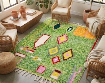 Può includere: Un tappeto rettangolare a pelo lungo con una base verde brillante. Il tappeto è decorato con varie forme geometriche in giallo, rosa, rosso, arancione e bianco, e presenta un bordo con frange sui lati più corti.