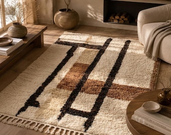 Può includere: Un tappeto rettangolare a pelo lungo con una consistenza morbida nei toni del crema, marrone chiaro e marrone scuro. Il design presenta audaci linee geometriche marrone scuro che si intersecano su uno sfondo crema con accenti marrone chiaro.
