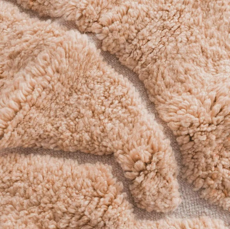 Minimalist Moroccan rug in a warm peach shade with modern geometric lines, perfect for Pinterest-inspired interiors. Handmade soft wool texture for cozy bedroom decor, stylish living rooms, or aesthetic content creator setups. This rug screams soft luxury, quiet comfort, and effortless viral style. Ideal for boho homes, apartment styling, and Instagram-worthy vibes.