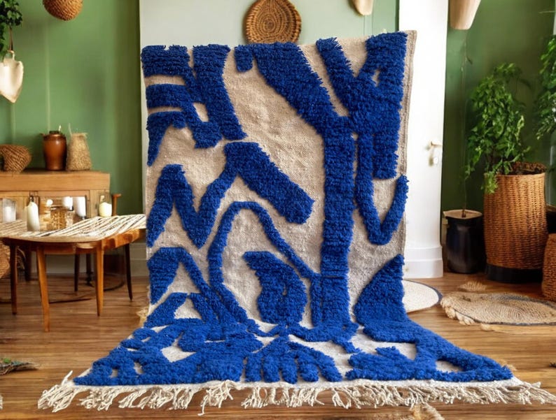 A vintage Moroccan wool rug with a bold blue abstract design handwoven on a neutral beige background, featuring plush texture and traditional fringed edges Vintage Rug, Moroccan Rug Wool Rug Abstract Rug Handwoven Rug Blue Rug Bold Design Modern Rug