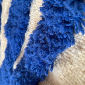 A vintage Moroccan wool rug with a bold blue abstract design handwoven on a neutral beige background, featuring plush texture and traditional fringed edges Vintage Rug, Moroccan Rug Wool Rug Abstract Rug Handwoven Rug Blue Rug Bold Design Modern Rug