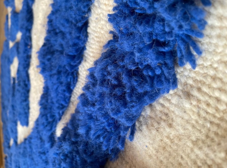 A vintage Moroccan wool rug with a bold blue abstract design handwoven on a neutral beige background, featuring plush texture and traditional fringed edges Vintage Rug, Moroccan Rug Wool Rug Abstract Rug Handwoven Rug Blue Rug Bold Design Modern Rug
