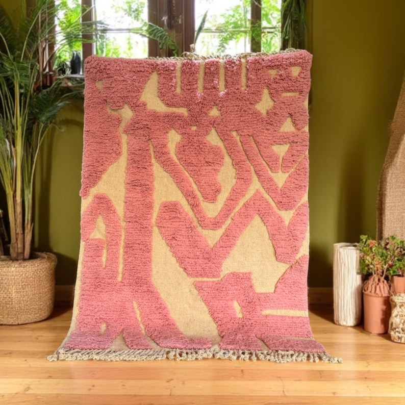 Modern abstract Moroccan Beni Mrirt rug featuring soft pink and beige tones with artistic organic patterns. Handwoven with premium wool by Amazigh artisans in Morocco. This boho-chic rug is perfect for adding an artistic touch to contemporary, minimalist, or eclectic interiors. Plush and cozy underfoot, it’s ideal for living rooms, bedrooms, and stylish creative spaces. Unique handmade piece crafted with passion and heritage.