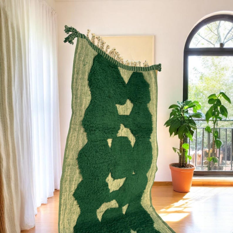 Extra-long Moroccan runner rug in deep green with bold organic patterns and beige wool base. This handcrafted Beni Ourain wool carpet is perfect for hallways, corridors, and modern interiors needing a unique, earthy touch. Made by Berber artisans using natural wool, it combines luxury softness and geometric structure. Ideal for minimalist, boho, or Japandi-style homes.