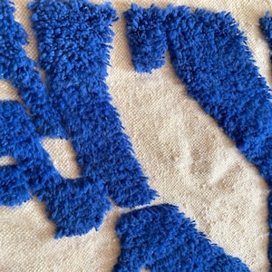 A vintage Moroccan wool rug with a bold blue abstract design handwoven on a neutral beige background, featuring plush texture and traditional fringed edges Vintage Rug, Moroccan Rug Wool Rug Abstract Rug Handwoven Rug Blue Rug Bold Design Modern Rug