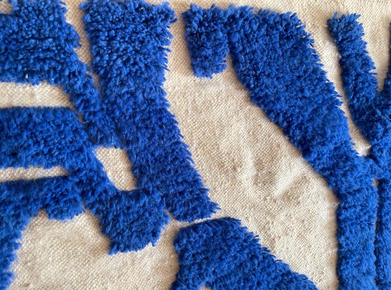A vintage Moroccan wool rug with a bold blue abstract design handwoven on a neutral beige background, featuring plush texture and traditional fringed edges Vintage Rug, Moroccan Rug Wool Rug Abstract Rug Handwoven Rug Blue Rug Bold Design Modern Rug