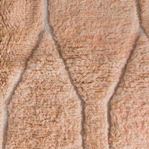 Minimalist Moroccan rug in a warm peach shade with modern geometric lines, perfect for Pinterest-inspired interiors. Handmade soft wool texture for cozy bedroom decor, stylish living rooms, or aesthetic content creator setups. This rug screams soft luxury, quiet comfort, and effortless viral style. Ideal for boho homes, apartment styling, and Instagram-worthy vibes.
