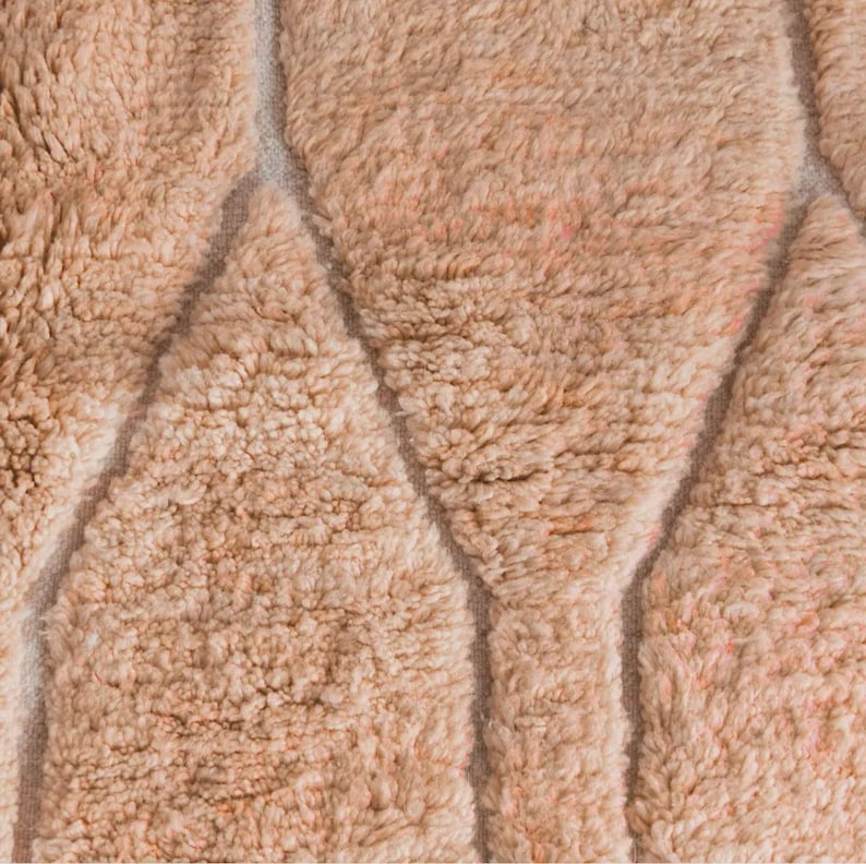 Minimalist Moroccan rug in a warm peach shade with modern geometric lines, perfect for Pinterest-inspired interiors. Handmade soft wool texture for cozy bedroom decor, stylish living rooms, or aesthetic content creator setups. This rug screams soft luxury, quiet comfort, and effortless viral style. Ideal for boho homes, apartment styling, and Instagram-worthy vibes.