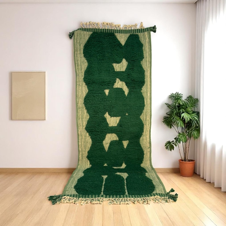 Extra-long Moroccan runner rug in deep green with bold organic patterns and beige wool base. This handcrafted Beni Ourain wool carpet is perfect for hallways, corridors, and modern interiors needing a unique, earthy touch. Made by Berber artisans using natural wool, it combines luxury softness and geometric structure. Ideal for minimalist, boho, or Japandi-style homes.