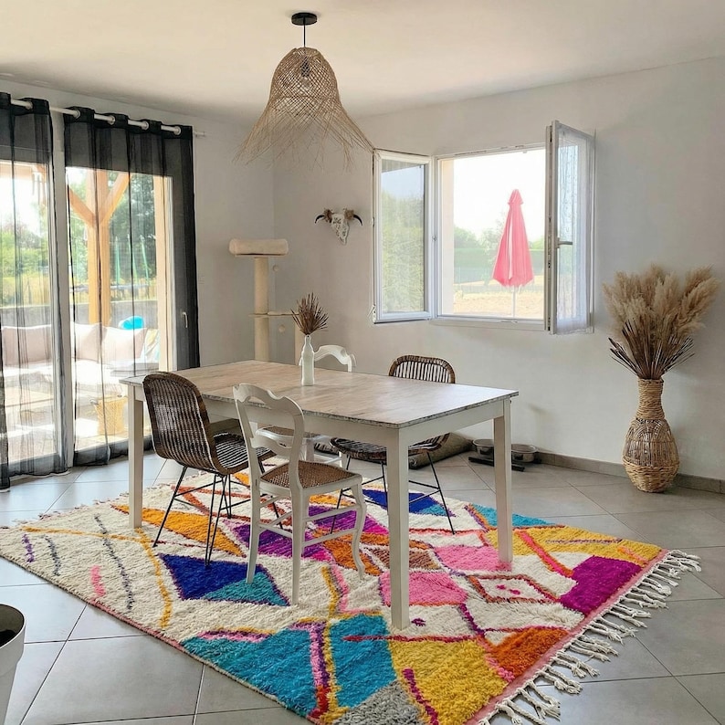 Authentic handmade Moroccan Boujaad rug featuring bold geometric diamond patterns in vibrant multicolor — electric blue, fuchsia pink, orange, yellow and purple on ivory wool background. Hand-knotted by Berber artisans in Morocco using natural wool. Perfect boho statement rug for living room, bedroom or dining room. One-of-a-kind colorful area rug with traditional fringe.