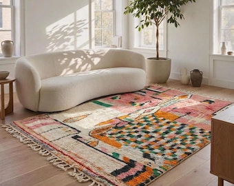 Può includere: Un tappeto rettangolare con base color crema e un motivo geometrico multicolore nelle tonalità del rosa, arancione, verde e nero. Il tappeto presenta un pelo strutturato ed è rifinito con frange annodate sui lati corti.