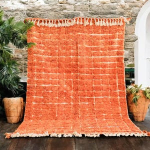 Soft peach Moroccan rug with light pink grid pattern, handcrafted by Berber artisans using 100% natural wool. Unique Boujad style with fluffy texture, ideal for cozy interiors, nurseries, boho bedrooms, and minimalist homes. Custom sizing available.