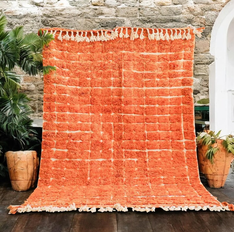 Soft peach Moroccan rug with light pink grid pattern, handcrafted by Berber artisans using 100% natural wool. Unique Boujad style with fluffy texture, ideal for cozy interiors, nurseries, boho bedrooms, and minimalist homes. Custom sizing available.