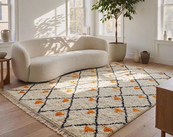 Può includere: Un tappeto rettangolare con base color crema, un motivo a griglia a rombi neri e piccoli accenti trapuntati arancioni all'interno di ogni rombo. Il tappeto ha un pelo spesso e strutturato, rifinito con corte frange annodate sui bordi.