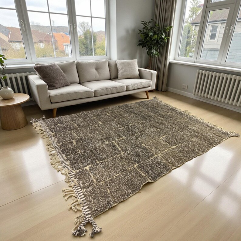 Handwoven Moroccan rug made from 100% natural wool in Travertine and White tones. Its rich texture and neutral color palette make it the perfect statement piece for modern, minimalist, or boho interiors. Crafted by Amazigh artisans in the Atlas Mountains, this rug combines traditional Moroccan weaving with a soft, earthy design. Ideal for living rooms, bedrooms, or cozy reading spaces, it brings warmth and timeless elegance to your home.