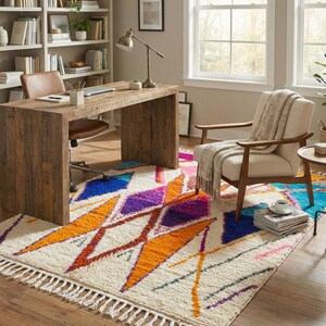 Authentic handmade Moroccan Boujaad rug featuring bold geometric diamond patterns in vibrant multicolor — electric blue, fuchsia pink, orange, yellow and purple on ivory wool background. Hand-knotted by Berber artisans in Morocco using natural wool. Perfect boho statement rug for living room, bedroom or dining room. One-of-a-kind colorful area rug with traditional fringe.