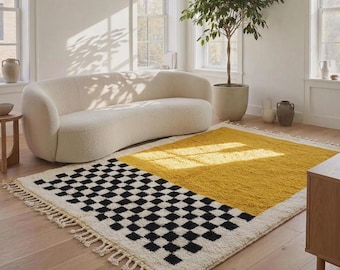 Può includere: Un tappeto rettangolare a pelo lungo con un design diviso. Una metà presenta un motivo a scacchi bianco e nero, mentre l'altra metà è di un colore giallo senape solido. Il tappeto è rifinito con frange color crema su entrambe le estremità.