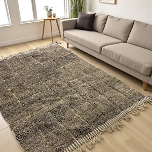 Handwoven Moroccan rug made from 100% natural wool in Travertine and White tones. Its rich texture and neutral color palette make it the perfect statement piece for modern, minimalist, or boho interiors. Crafted by Amazigh artisans in the Atlas Mountains, this rug combines traditional Moroccan weaving with a soft, earthy design. Ideal for living rooms, bedrooms, or cozy reading spaces, it brings warmth and timeless elegance to your home.