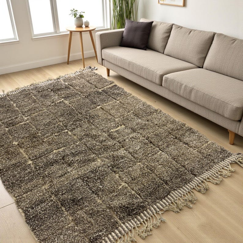Handwoven Moroccan rug made from 100% natural wool in Travertine and White tones. Its rich texture and neutral color palette make it the perfect statement piece for modern, minimalist, or boho interiors. Crafted by Amazigh artisans in the Atlas Mountains, this rug combines traditional Moroccan weaving with a soft, earthy design. Ideal for living rooms, bedrooms, or cozy reading spaces, it brings warmth and timeless elegance to your home.
