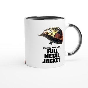 Peut inclure: Une tasse en céramique blanche avec un bord et une poignée noirs. La tasse présente une image en noir et blanc d'un casque militaire avec les mots "Born to Kill" écrits dessus. Le texte "Stanley Kubrick's Full Metal Jacket" est imprimé sous le casque.