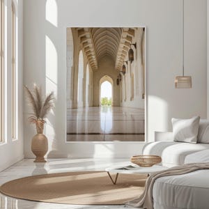 Peut inclure: Une photographie d'un couloir blanc avec des portes cintrées et une vue sur une cour à travers le bout du couloir. Le couloir est éclairé par la lumière du soleil qui pénètre de la cour.