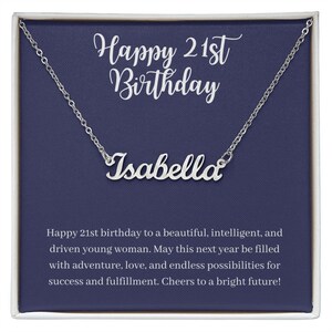Może przedstawiać: Srebrny naszyjnik z imieniem "Isabella" w ozdobnym kroju pisma, prezentowany na granatowej karcie. Karta zawiera napis "Happy 21st Birthday" w białym kolorze, z życzeniami.