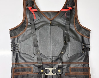 May include: A black leather vest with brown accents and a zip closure. The vest has multiple straps and buckles, and a mesh panel on the back.