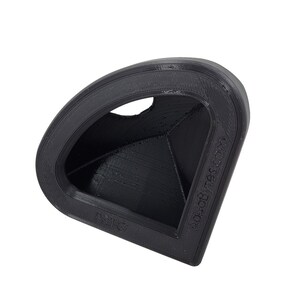May include: A black 3D printed corner piece with a triangular opening. The piece is designed to fit into a corner and create a smooth transition between two surfaces.