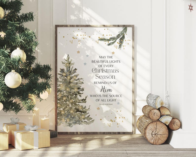 May include: A framed print featuring a watercolour Christmas tree and the text "MAY THE BEAUTIFUL LIGHTS OF EVERY Christmas Season REMIND US OF Him WHO IS THE SOURCE OF ALL LIGHT". The print is displayed near a decorated Christmas tree.